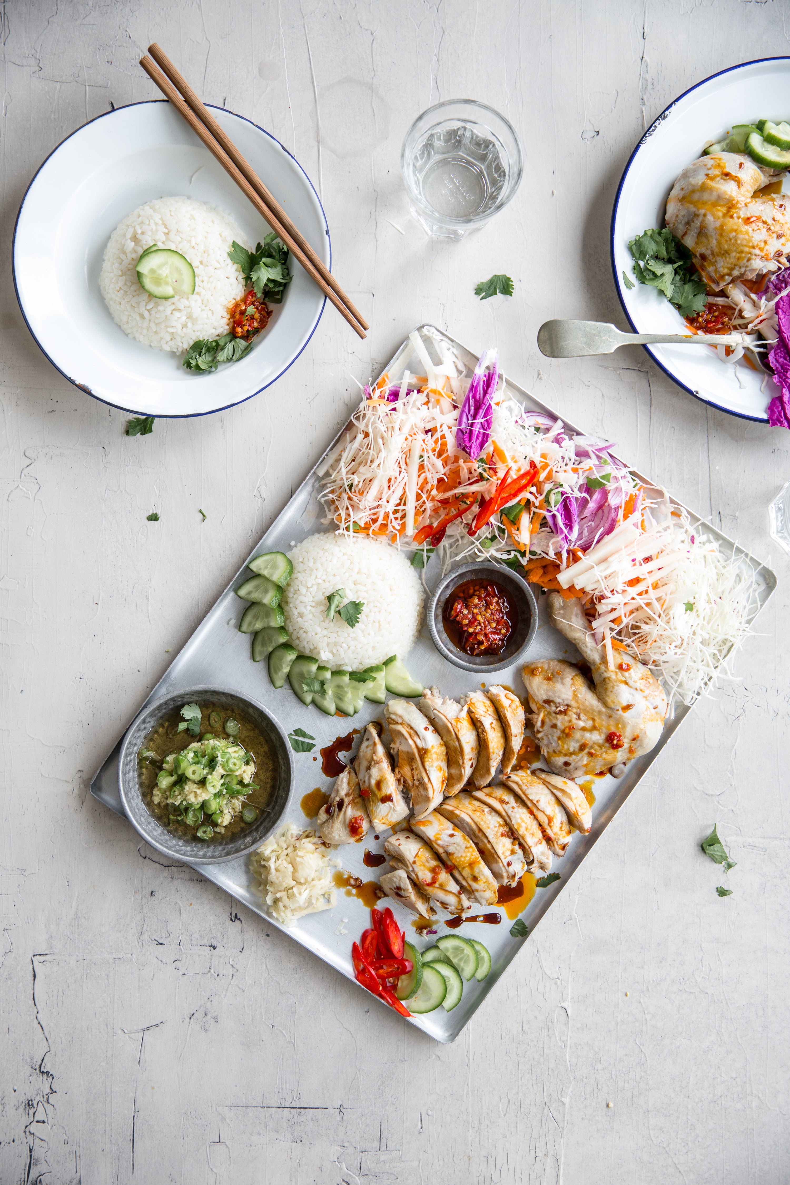 Plated dish of chicken with rice and vegetables on a light gray surface